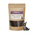 Load image into Gallery viewer, A stand-up pouch of Hugo & Co. Turkey & Cranberry Dog Treats on a lavender background with white snowflake graphics.
