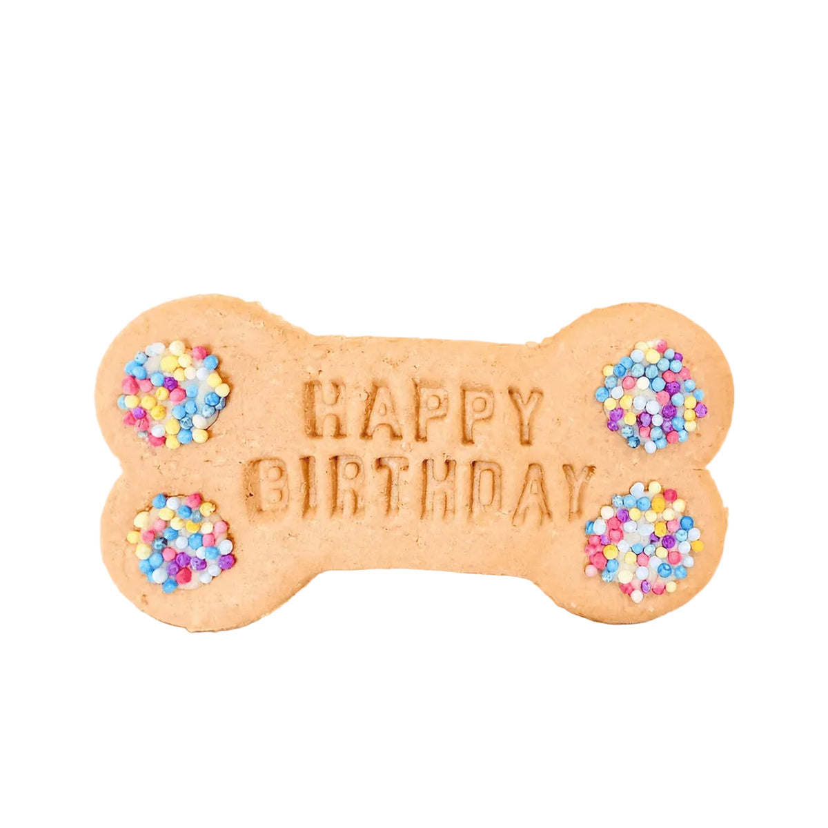 A bone-shaped dog treat cookie with 'HAPPY BIRTHDAY' embossed in the center, decorated with colorful sprinkles in the four corners, set on a light beige fabric background with festive confetti and party ribbons.