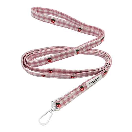 A pink and white gingham dog leash with embroidered red strawberries and a silver metal carabiner, shown on a clean white background.