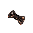 Load image into Gallery viewer, A dark brown fabric hair bow with a cute Halloween print of smiling pumpkins, crescent moons, and white ghosts,
