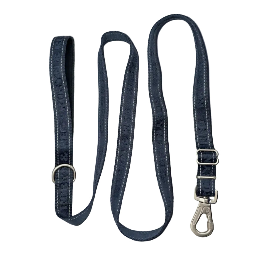 A midnight blue dog leash with white contrast stitching, featuring the brand name printed repeatedly on the strap, a silver metal D-ring on one end, and a silver carabiner clip on the other