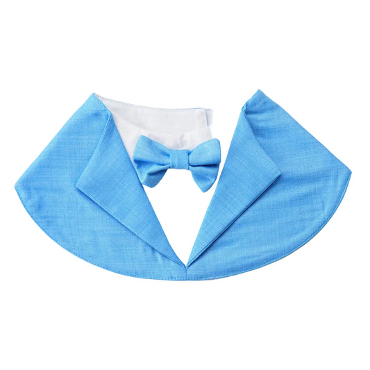 A light blue fabric pet collar designed to look like a tuxedo lapel, featuring a matching blue bow tie and a white faux shirt insert, displayed on a light gray background with a 'Unique Dog' logo in the top-left corner.